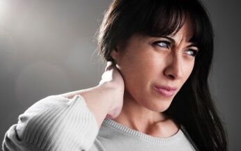 Una mujer está preocupada por los síntomas de la osteocondrosis cervical. 